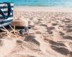 Sac, chapeau de paille, lunettes de soleil posés sur le sable d'une plage
