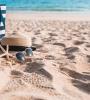 Sac, chapeau de paille, lunettes de soleil posés sur le sable d'une plage