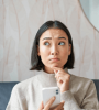 Femme songeuse sur son téléphone