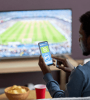 Jeune sur son téléphone devant un match