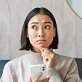 Femme songeuse sur son téléphone