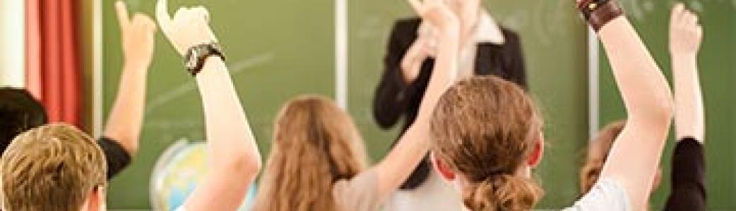 classe d'élèves levant la main