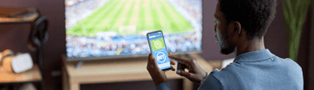 Jeune sur son téléphone devant un match
