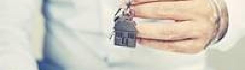 Homme qui tient des clés avec un porte-clé maison