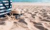 Sac, chapeau de paille, lunettes de soleil posés sur le sable d'une plage