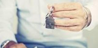 Homme qui tient des clés avec un porte-clé maison