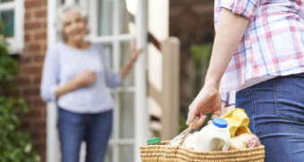 Aidant qui apporte les courses à une femme âgée
