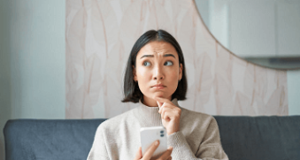 Femme songeuse sur son téléphone