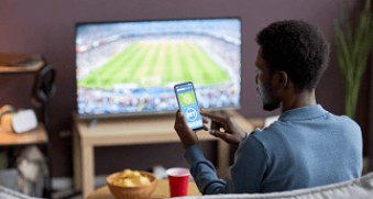 Jeune sur son téléphone devant un match
