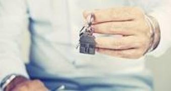 Homme qui tient des clés avec un porte-clé maison