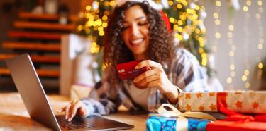 Femme qui achète avec sa carte bancaire sur son ordinateur