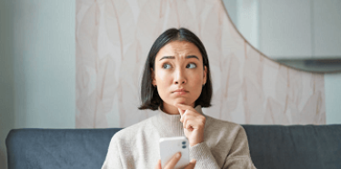Femme songeuse sur son téléphone