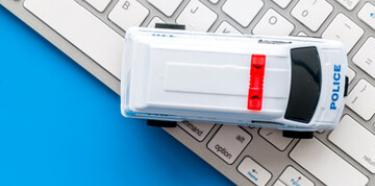 Voiture de police miniature sur un clavier d'ordinateur